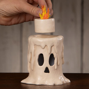 Cream-colored ceramic skull candle luminary with dripping wax effect and orange-yellow paper flame small flam’in candle luminary