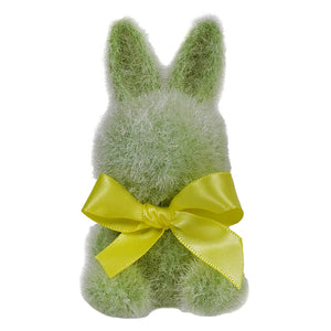 Green fuzzy bunny decoration with a yellow bow tied around its middle.
