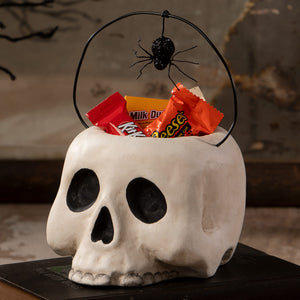 Small grim bucket is a white plastic skull candy basket with black eye sockets and a spider handle for halloween decor