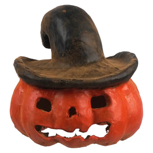 A small rustic orange pumpkin jack o lantern with a carved face wearing a dark weathered witch hat