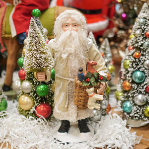Small santa figure by bethany lowe designs in cream fur coat holding miniature christmas tree and toy basket with ornaments
