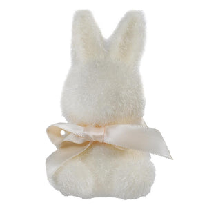 White plush bunny with a cream-colored ribbon bow around its neck.