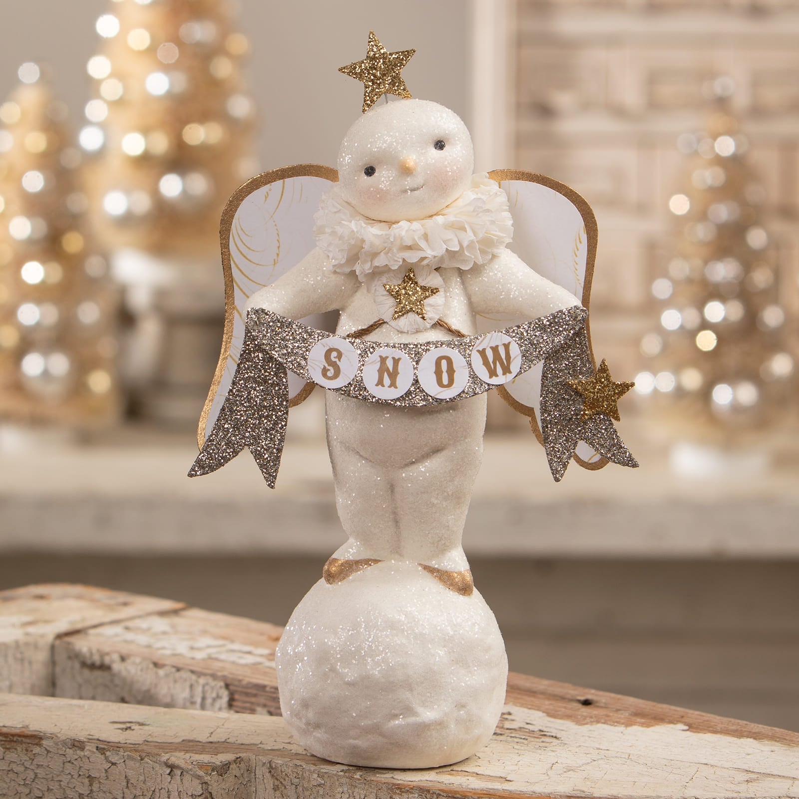 A glittery white snow angel figurine with gold wings holding a snow banner perfect for classic angel tree toppers and decor