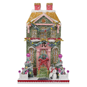 A glittery green snowman manor christmas house ornament with pink trim gold accents and festive decorations from cody foster