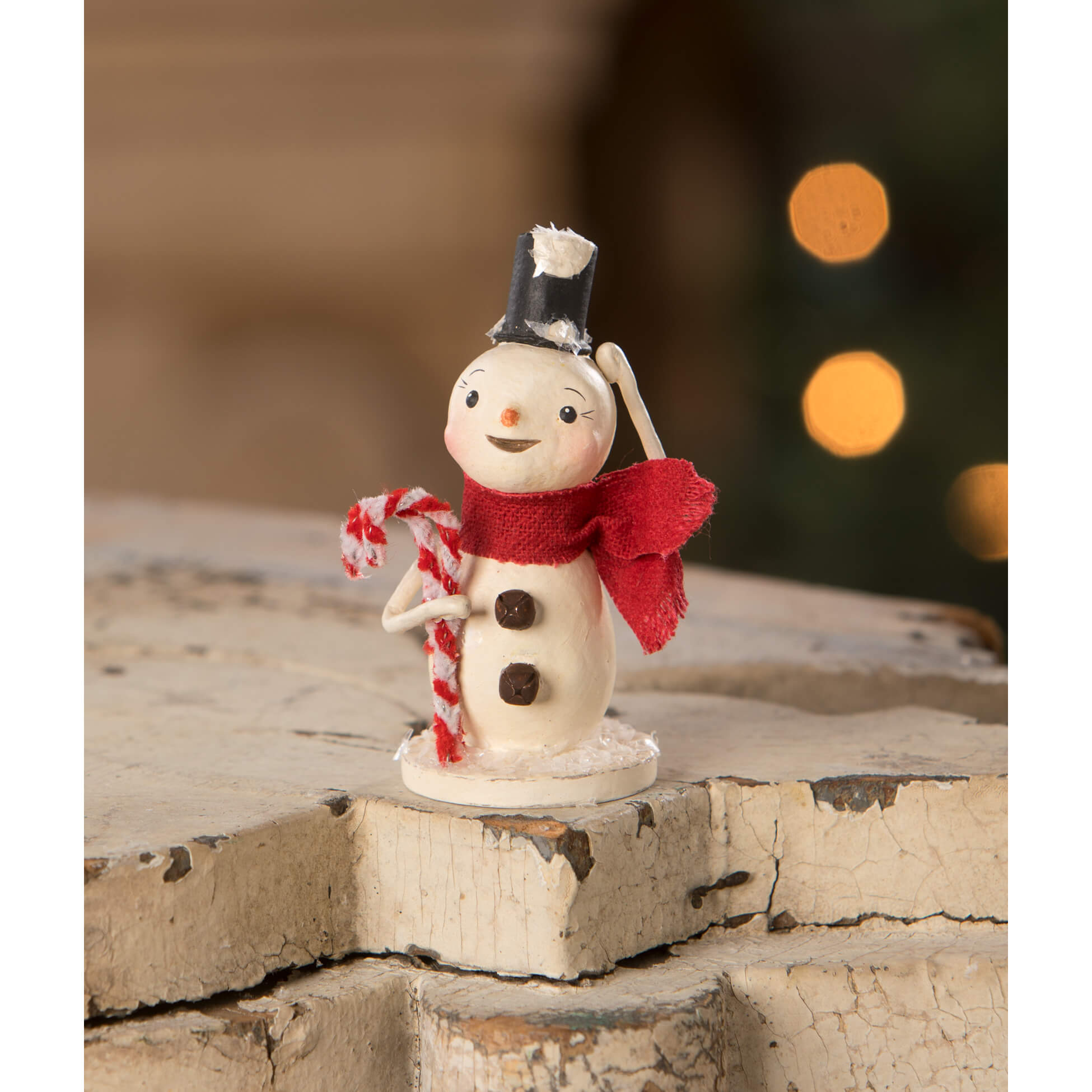 A charming white christmas snowman figure with black top hat red scarf and candy canes by bethany lowe designs