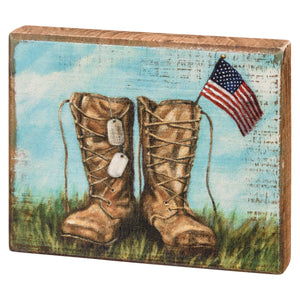 Military combat boots with dog tags and an American flag.