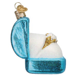 Something blue ring box ornament is a translucent blue glass figural decor with gold heart tag holding a golden diamond ring