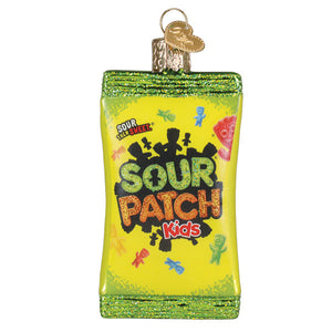 A vibrant yellow glass sour patch kids ornament shaped like a candy bag with glittery green edges and colorful characters