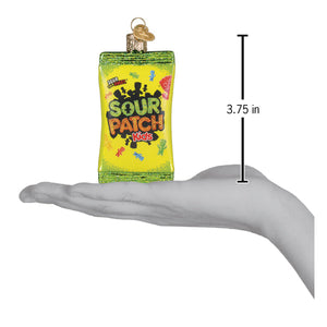 A vibrant green and yellow glass sour patch kids dessert ornament shaped like a candy bag with colorful characters