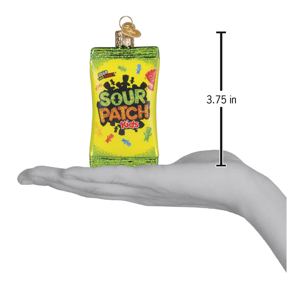 A vibrant green and yellow glass sour patch kids dessert ornament shaped like a candy bag with colorful characters