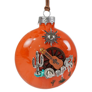 Vibrant orange glass southwest serenade ornament decorated with silver and brown western charms by bette day