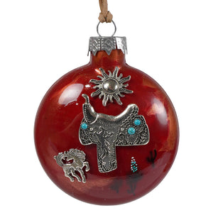 Red handcrafted glass ornament featuring a silver cowboy saddle with turquoise accents sun and southwestern details