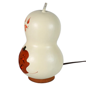 Cream-colored lighted ghost gourd with carved orange pumpkin and leaf designs from meadowbrooke gourds spooky boo