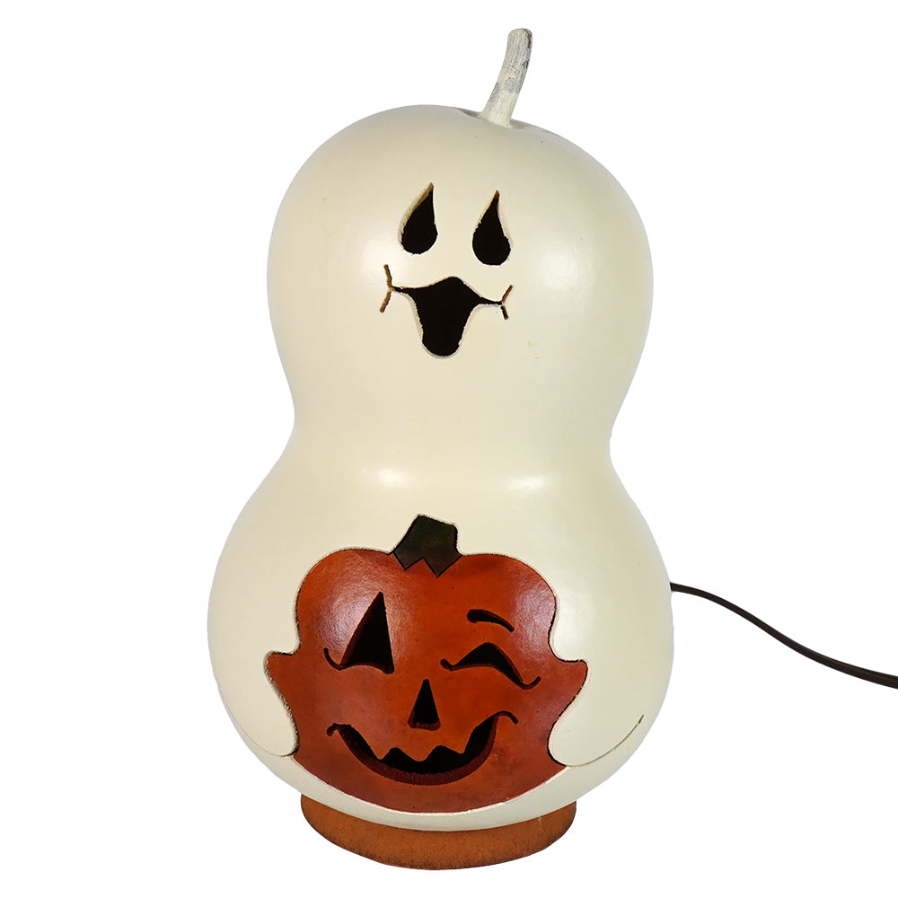 Spooky boo small lighted ghost gourd from meadowbrooke gourds glowing orange in halloween decoration setup