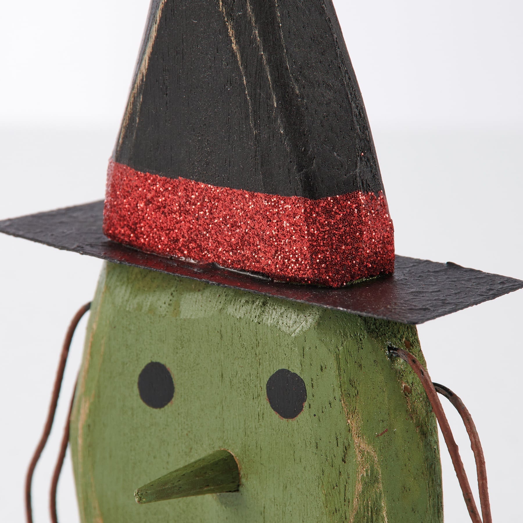 Green wooden witch figurine with black hat and red glitter accent from a vintage inspired spooky ornament set