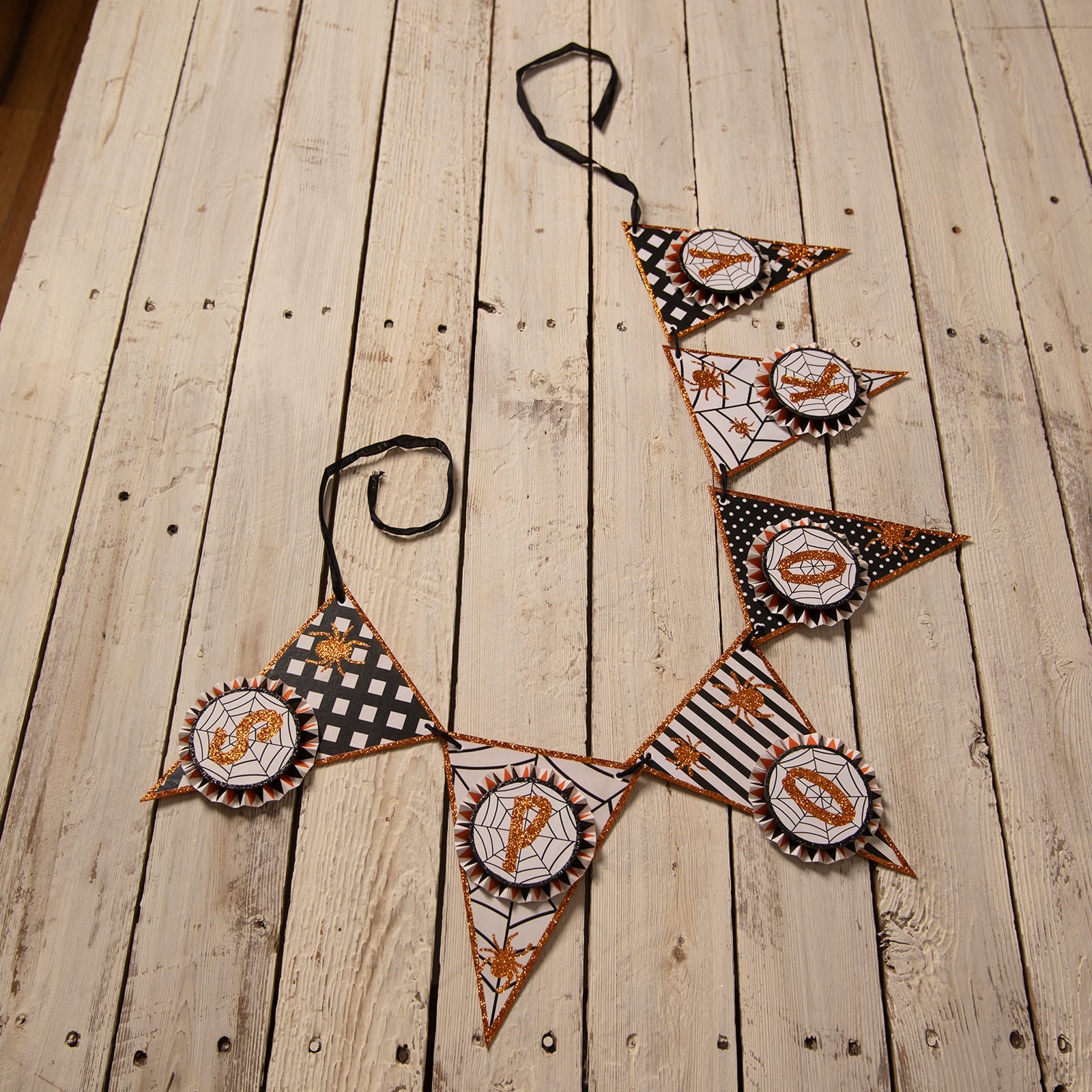 Spooky spider garland halloween garlands with black white and orange paper flags and glittery spiderweb designs by bethany lowe