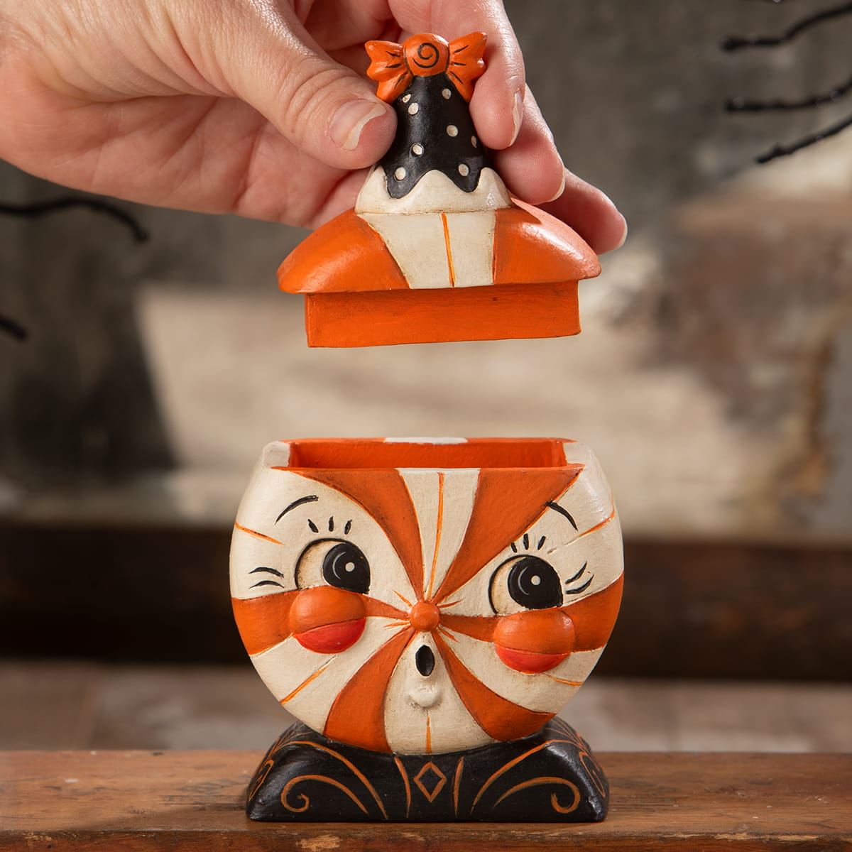 Orange and white candy-striped ceramic treat box with black polka dot lid and orange bow for spooky jack o lantern gifts