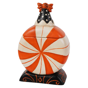 Orange and white striped candy cane cookie jar with black polka dot lid and orange bow in spooky surprise treat box with jack o lantern theme