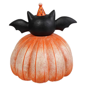 Black bat figurine with spread wings wearing a festive orange hat on an orange pumpkin base halloween pumpkins and gourds