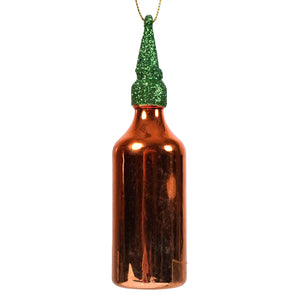 A shiny copper sriracha hot chili sauce ornament with a glittery green cap and gold string for hanging