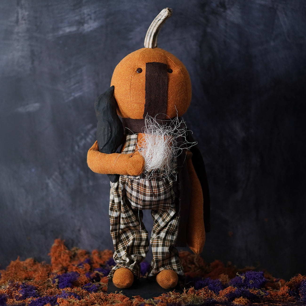 Orange pumpkin-shaped plush standing scarecrow with black cape and plaid pants handcrafted folk art design