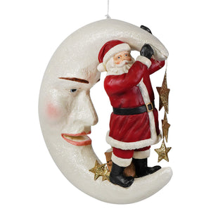 A festive bethany lowe designs santa figure in a red suit standing on a glittery crescent moon holding golden stars
