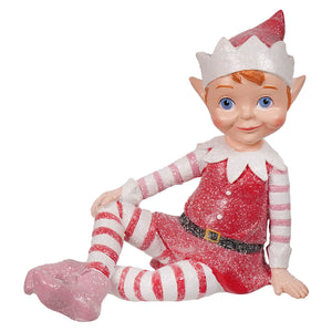 A glittery red and white resin elf figurine with blue eyes wearing a striped outfit perfect for sugar coated sweet christmas tabletop decor