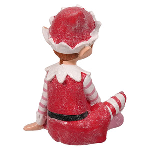 A glittery red and white sugar coated sweet resin elf figurine with striped sleeves and snowflake details