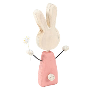 A charming sunny bunny chunky sitter wooden figurine with a distressed white finish and pink dress holding a daisy