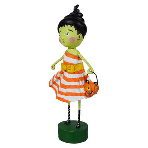 A whimsical lori mitchell halloween figurine susie stein with green skin black topknot hair and striped orange dress holding pumpkin basket