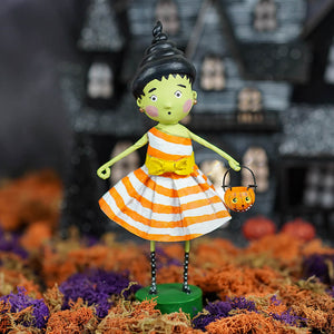 A lori mitchell halloween susie stein figurine with green skin, black spiral hair, striped dress, and pumpkin basket