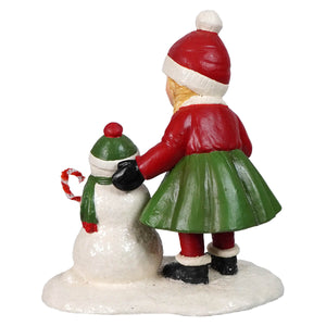 Susie holiday figurine by bethany lowe designs featuring red and green child in santa hat with christmas snowman decor