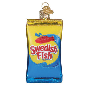 A glossy translucent glass swedish fish® ornament shaped like a candy bag with vibrant yellow blue colors and red fish logo