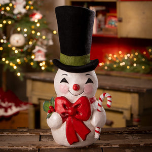 White ceramic snowman figurine with black top hat green band holding red bow and candy cane by bethany lowe designs