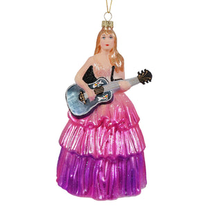 A cody foster translucent glass ornament of taylor swift playing guitar in a sparkling pink and purple layered gown
