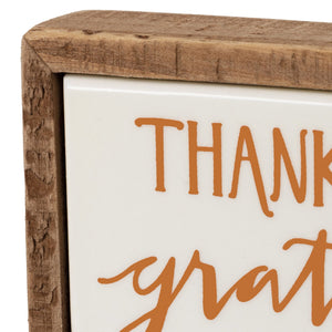 A rustic wooden frame mini wagon block sign with orange cursive thanks above grat on white background