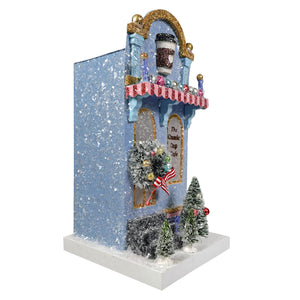 A festive blue classic cup cafe figurine by cody foster with glittery snowflakes gold trim wreath and light cord ready