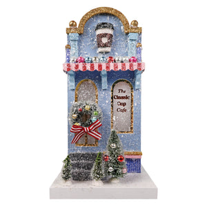 A festive blue and gold classic cup cafe miniature by cody foster with glittery snow and a red white striped awning