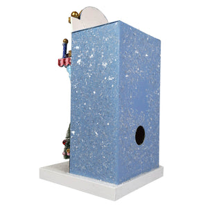 Blue glittery birdhouse with white base gold-trimmed roof and holiday decor from classic cup cafe by cody foster with light cord