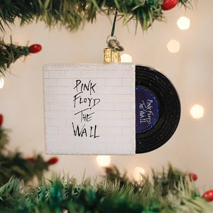 White brick-patterned pink floyd ornament vinyl record with pink floyd the wall text and glittery gold loop music ornament