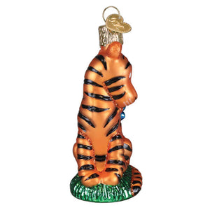 Orange glass tiger ornament with black stripes sitting on green base with gold heart tag perfect tigger ornament gift