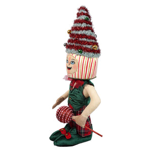 A festive toby tree standing doll elf wearing a green velvet vest and red plaid skirt holding a candy cane with striped hat