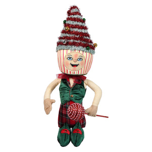 A festive toby tree standing doll with a red and white candy cane hat, green velvet vest, plaid skirt, and red lollipop