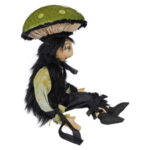 A whimsical handmade doll named tommy toadstool with black fur, green eyes, and tommys mushroom cap hat