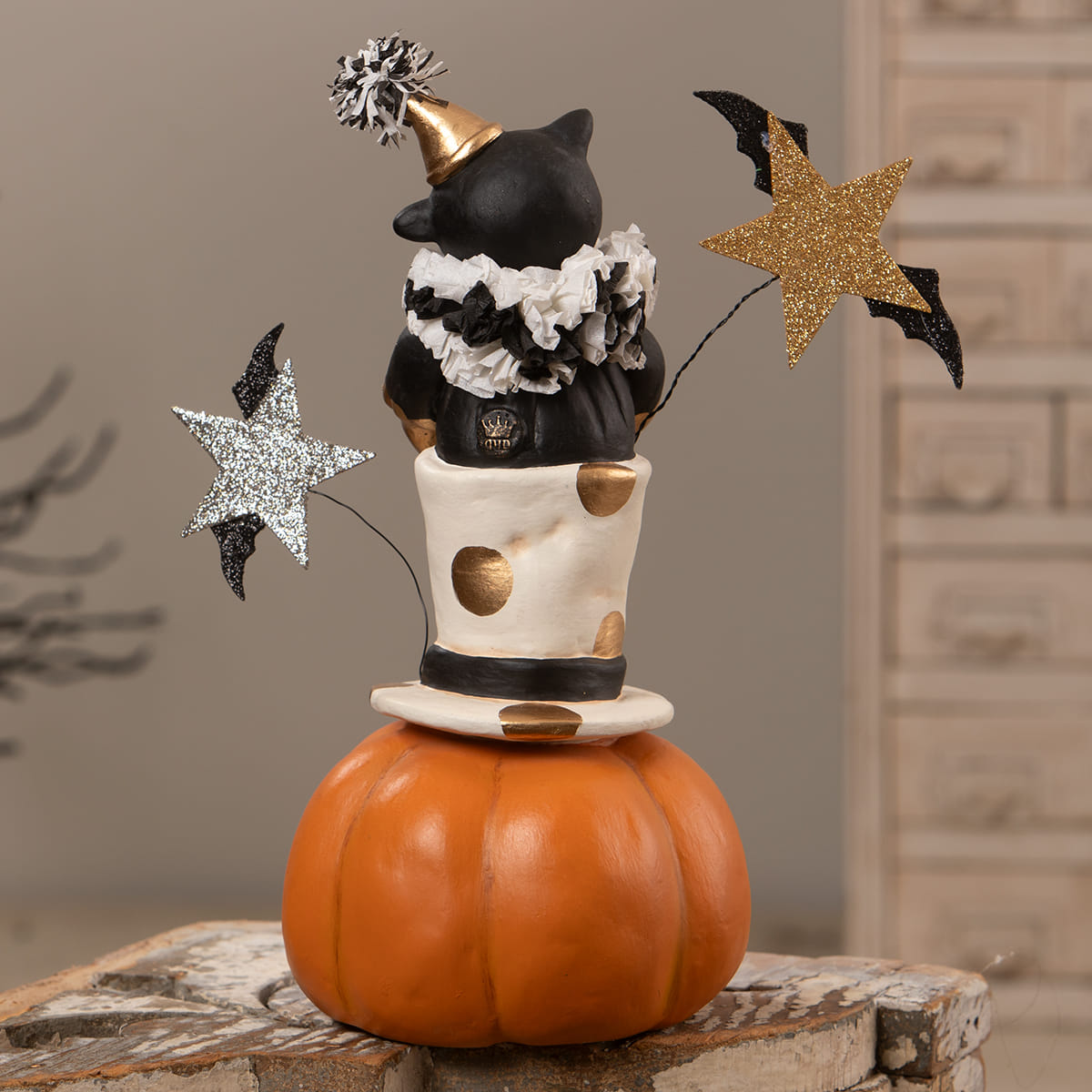 Top hat jack with cat featuring a black cat figurine in a gold party hat on a polka dot top hat over an orange jack o lantern