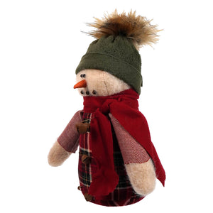 A baby snowman wearing traditional christmas attire with a green fluffy knit hat red scarf and plaid jacket