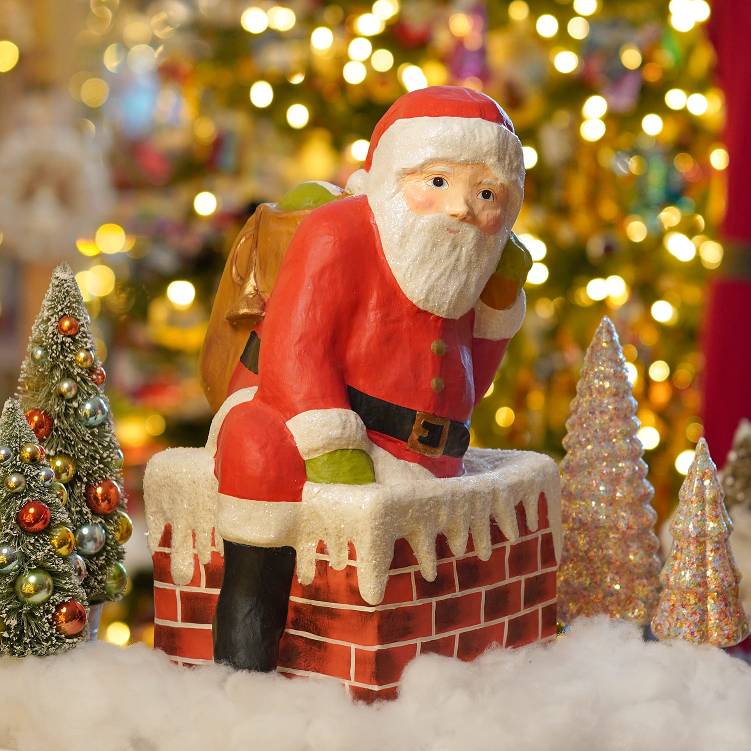 Traditional santa down chimney large paper mache figurine in red and white with black belt sitting on snowy brick chimney