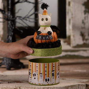 A white ceramic casper cat figurine with a candy-striped hat on an orange pumpkin treat box for halloween cats