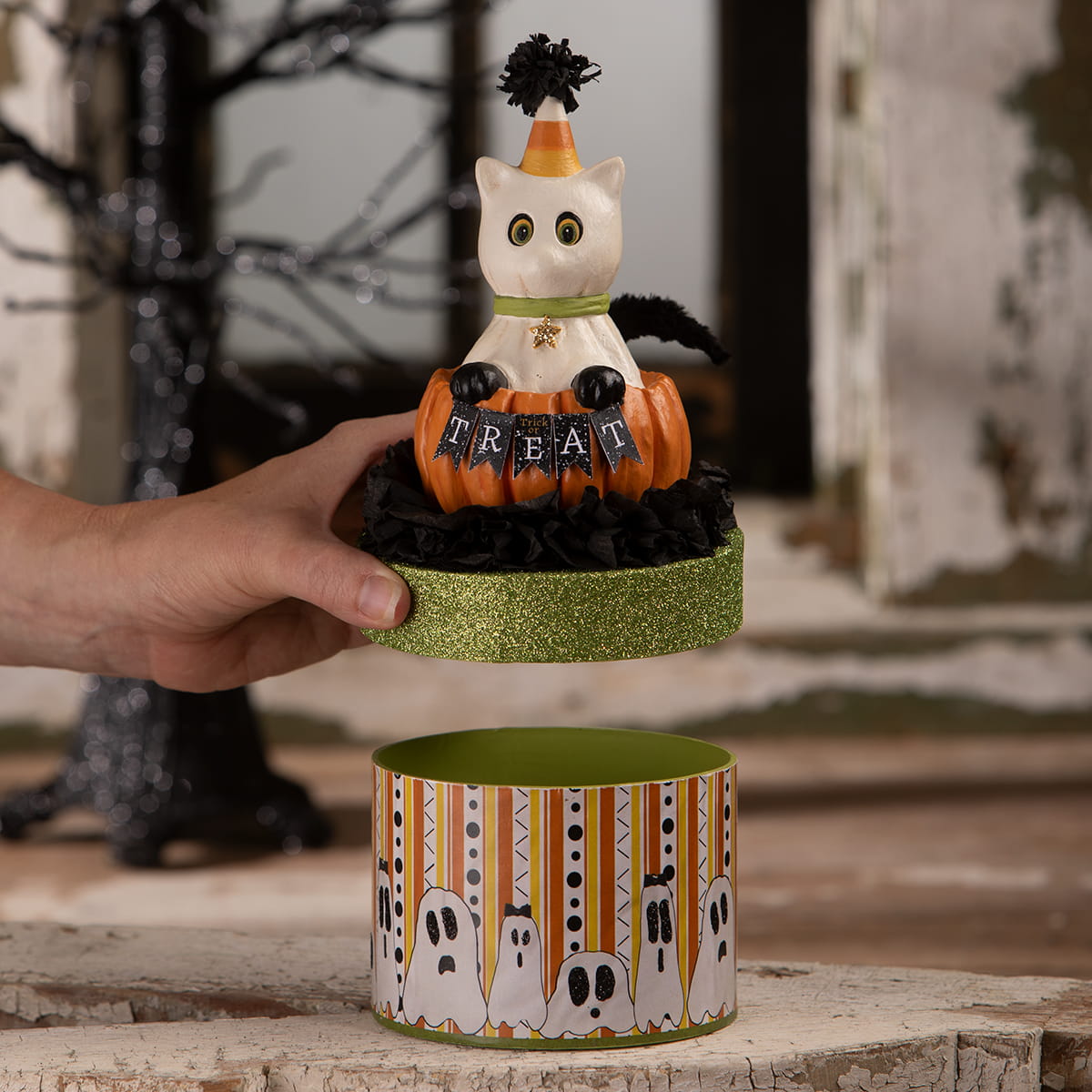 A white ceramic casper cat figurine with an orange black party hat on a pumpkin treat box perfect for halloween cats display