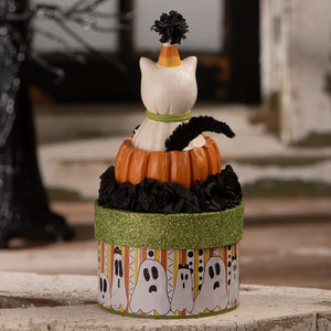 A white ceramic casper cat figurine with a candy corn hat on an orange pumpkin box with halloween cats theme